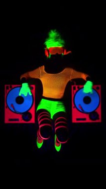 Havalı bir DJ kadın UV floresan giyiniyor ve dikey makyaj yapıyor.