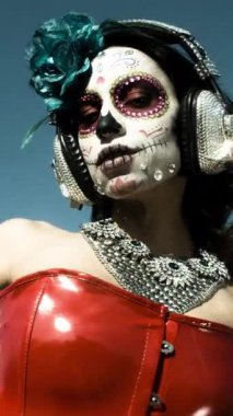 Özel olarak tasarlanmış kafatası şekerlemeleri olan güzel bir kadın. Ölü yüzünün Meksika günü dikey olarak makyaj yapıyor.