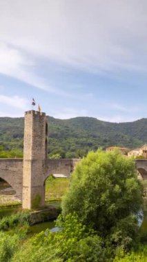 Besalu, Girona, İspanya 'da 12. yüzyıl Romanesk köprüsü ile sakin bir nehir sahnesinin zaman çizelgesi.