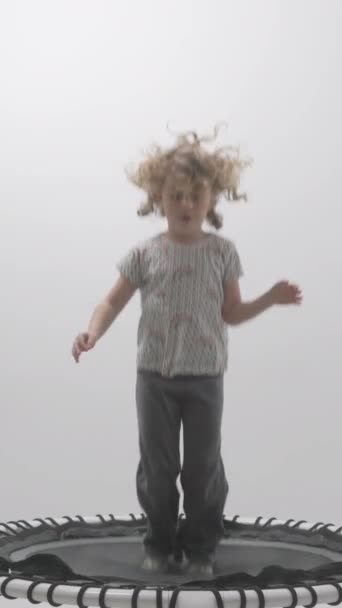 小さな女の子は垂直でゆっくりと動くトランポリンにジャンプ ストック動画