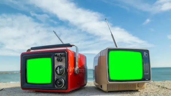 テレビに独自のコンテンツを追加するには 海の隣に緑色の画面を持つレトロテレビ ストック写真