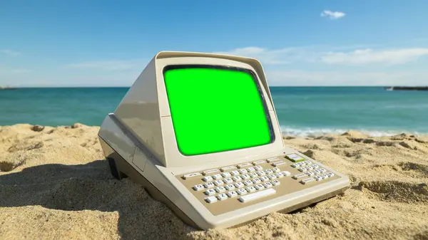 retro computer on a beach with green screen