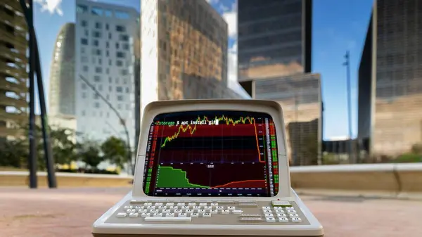 都市の高層スカイラインとストックと取引コードと画面上のデータを備えたレトロコンピュータ ロイヤリティフリーのストック写真