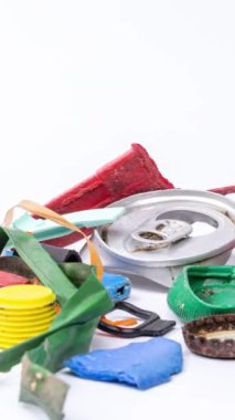 Dikey olarak beyaz arkaplan üzerinde oluşturulan plastik çöp ve atık ögelerinin makro durdurma hareketi