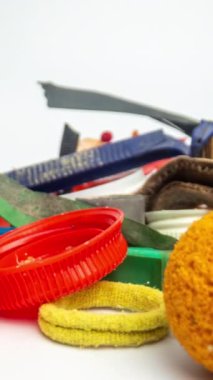 Dikey olarak beyaz arkaplan üzerinde oluşturulan plastik çöp ve atık ögelerinin makro durdurma hareketi