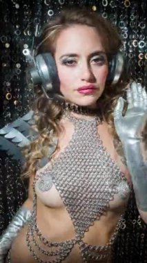 DJ disko kadını gümüş kristal burlesk kostüm ve dikey kulaklıkla poz veriyor