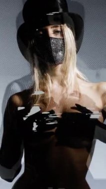 Siyah kostümlü ve dikey maske takan kadın.