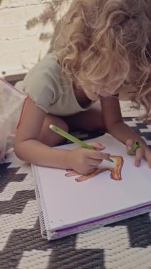 Açık havada dikey resim çizen renkli kalemler kullanan genç bir kız
