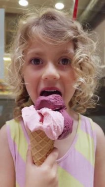 Meyve aromalı dondurmayı dikey yiyen genç bir kız.