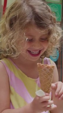 Meyve aromalı dondurmayı dikey yiyen genç bir kız.