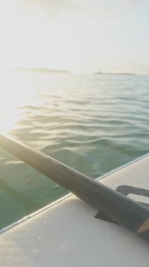 Şafak vakti ayakta kürek çekerken dikey olarak denizde.