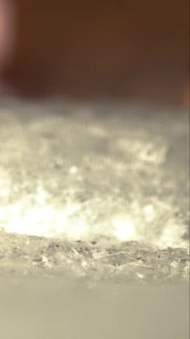 Bir garson buz bloğunu dikey çekimde yavaş çekimde küp kesiyor.