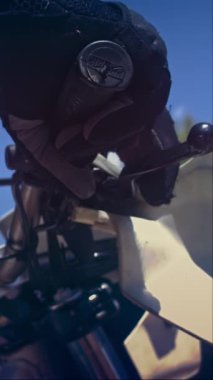 Motosikletin gidonunu dikey olarak kullanan eldivenli eller