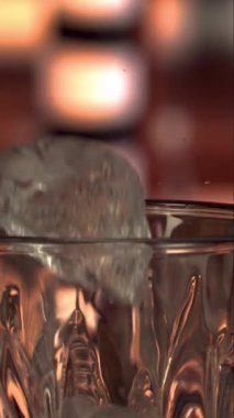 Buz küpleri yavaş çekimde dikey olarak cama bırakılıyor.