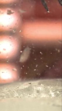 Bir garson buz bloğunu dikey çekimde yavaş çekimde küp kesiyor.