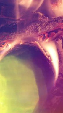 Dikey bir şöminede yanan odun ateşinde alevlerin yakın çekimi