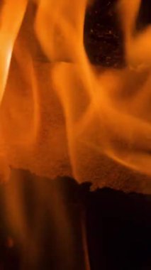 Dikey bir şöminede yanan odun ateşinde alevlerin yakın çekimi