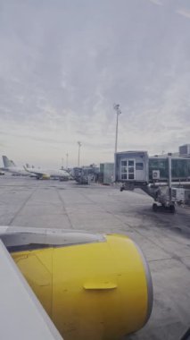 Bir uçak penceresinden dikey olarak havalimanına inen görüntüyü görüntüle