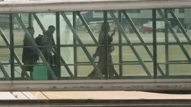 Uçaktan inen yolcular havaalanındaki gökyüzü köprüsünü kullanıyorlar.