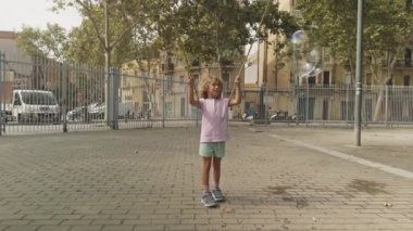 Sabunlu sıvıdan baloncuk yapan tatlı bir çocuk.