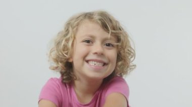 Kameraya poz veren sevimli, mutlu bir çocuk.