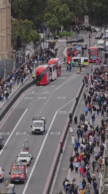 LONDON, İngiltere - 25 Eylül 2024: Trafik ve Westminster Köprüsü 'nden geçen insanlar parlamento, Londra' daki evlerin yanında dikey olarak