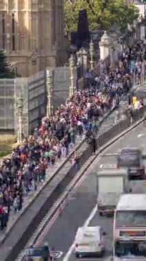 LONDON, İngiltere - 25 Eylül 2024: Trafik ve Westminster Köprüsü 'nden geçen insanlar parlamento, Londra' daki evlerin yanında dikey olarak