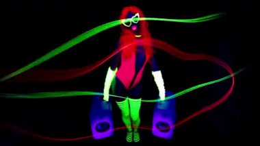 Ultraviyole floresan giyinen ve hoparlörlü makyaj yapan havalı dans eden bir kadın.