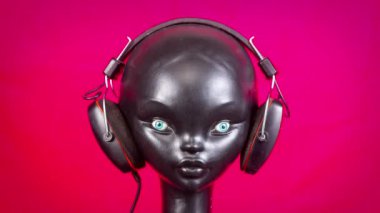 Retro kulaklıkları değişen bir mankenin stop motion videosu.
