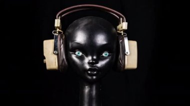 Retro kulaklıkları değişen bir mankenin stop motion videosu.