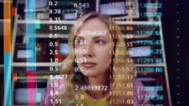 Arkasında bir televizyon ekranı olan kod ve verilerle etrafa bakan bir kadın.