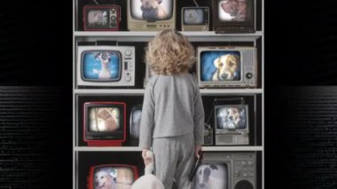 Genç kız ekranda köpeklerle televizyon seyrediyor.