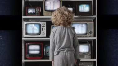 Genç kız ekranlarında elektrik santrallerinin videoları olan bir televizyon bankasını izliyor. 