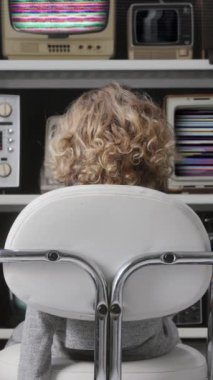 Genç kız ekranda dikey olarak bozuk ve bozuk bir dizi televizyon izliyor.