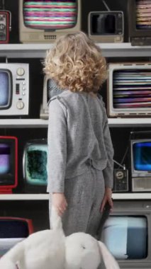 Genç kız ekranda dikey olarak bozuk ve bozuk bir dizi televizyon izliyor.