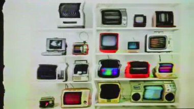 Raflarda antika ve eski televizyon koleksiyonu, ekranlarda parazit ve ağır arıza.
