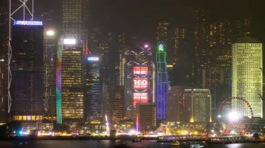 Hong Kong Central City 'nin gökdelenleri gece vakti ışıldarken kowloon limanının karşısından çekilen silueti. 