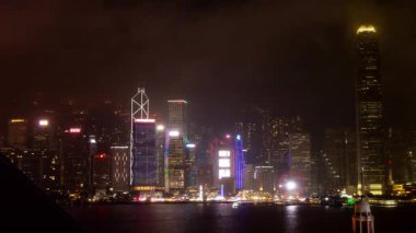 HONG KONG - 19 Mart 2025: Hong Kong Central City gökdelenleri gece boyunca ışıldarken Kowloon limanının karşısındaki gökdelenlerden gökyüzü görüntülendi. 