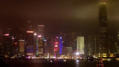 HONG KONG - 19 Mart 2025: Hong Kong Central City gökdelenleri gece boyunca ışıldarken Kowloon limanının karşısındaki gökdelenlerden gökyüzü görüntülendi. 