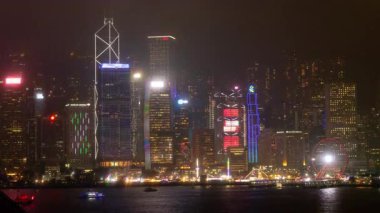 HONG KONG - 19 Mart 2025: Hong Kong Central City gökdelenleri gece boyunca ışıldarken Kowloon limanının karşısındaki gökdelenlerden gökyüzü görüntülendi. 