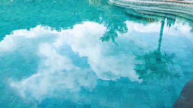 Sudaki bulutların yansımalarıyla dolu lüks yüzme havuzu zamanı.