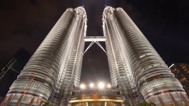 KUALA LUMPUR - 29 Mart 2025: Petronas kuleleri ve Kuala Lumpur gökdelenlerinin geceleyin sokak seviyesinden zamanlaması
