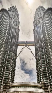 KUALA LUMPUR - 29 Mart 2025: Petronas kuleleri ve Kuala Lumpur ufuk çizgisinin dikey olarak sokak seviyesinden zamanlaması