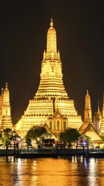 BANGKOK, THAILAND - 25 Mart 2025: Bangkok 'taki ünlü Wat Arun Tapınağı' nın zamanlaması geceleyin dikey olarak Chao