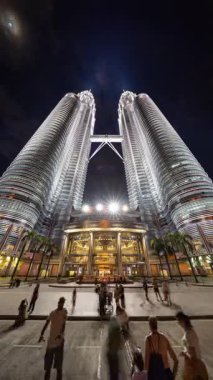 KUALA LUMPUR, MALAYSIA - 29 Mart 2025: geceleyin Kuala Lumpur 'daki petronas kulelerinin dikey olarak geniş açılı zaman çizelgesi