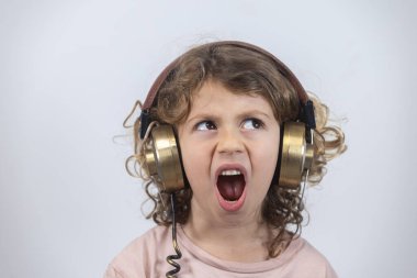 Küçük sevimli çocuk eski kulaklık takıyor.