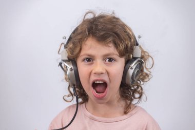 Küçük sevimli çocuk eski kulaklık takıyor.