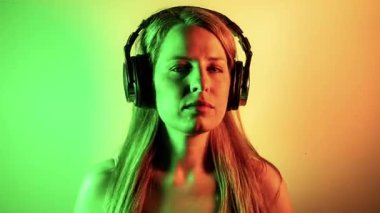 Müzik dinlemek için kulaklıkları olan havalı bayan dansçı ve renkli disko ışıkları.