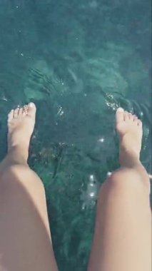 Yunanca bir yatın yüzme güvertesinde küçük bir kızın bacakları.