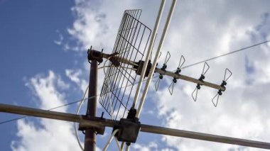 Gökyüzünün zaman çizelgesi ve ön planda televizyon anteni olan bulutlar. 